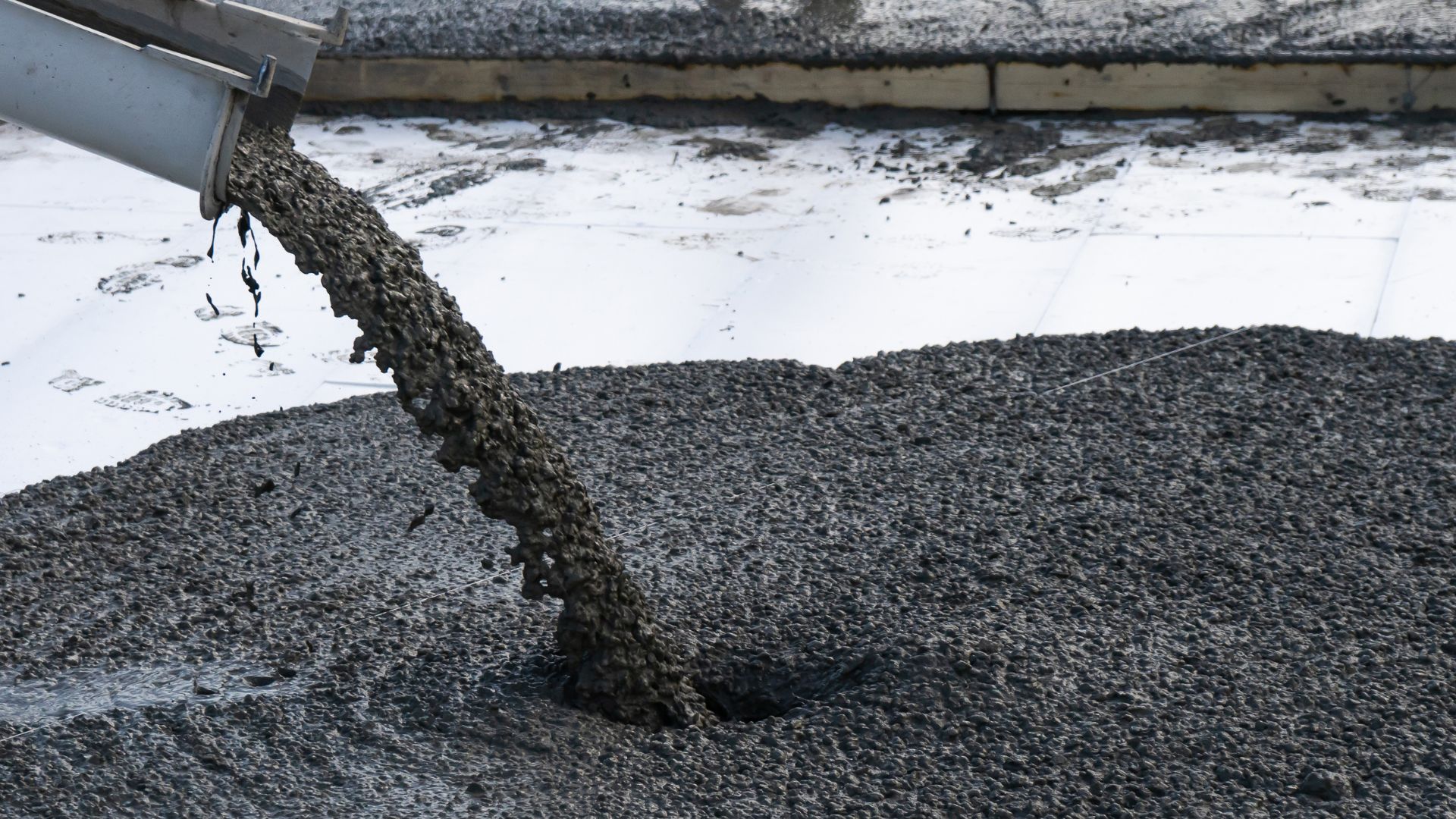 A cement mixer pouring cement into a bucket